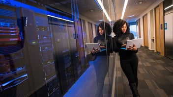 woman standing with a laptop in a datacenter